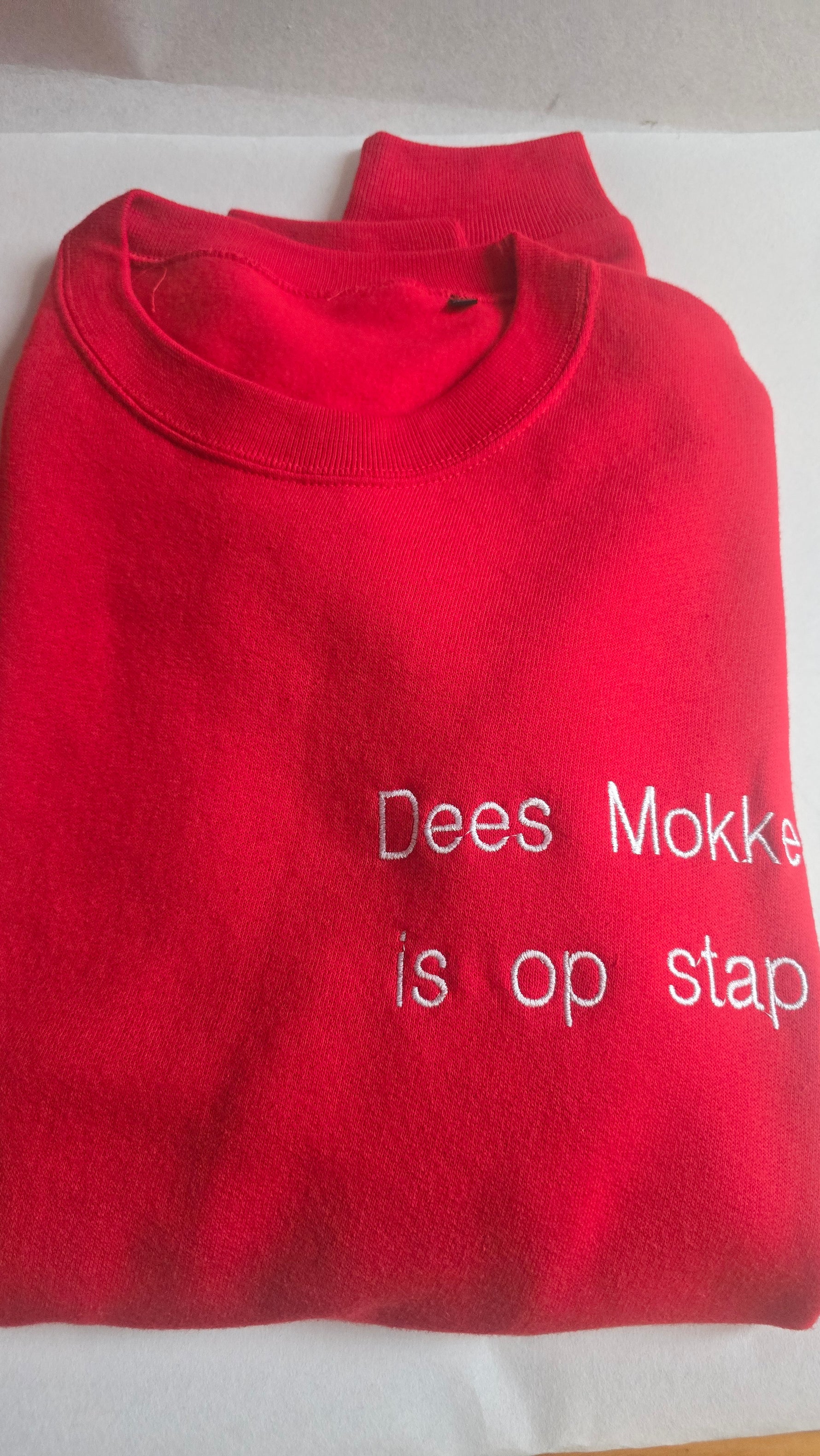 Opvallende rode sweater met een uniek en exclusief geborduurd De Mokkes design