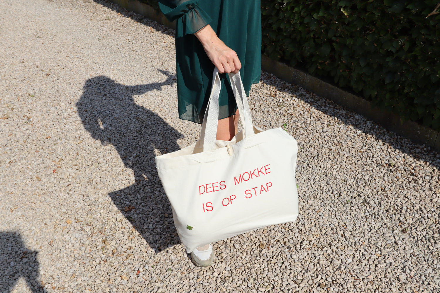 Beige shopper met de in het rood geborduurde tekst 'Dees mokke is op stap' – De Mokkes