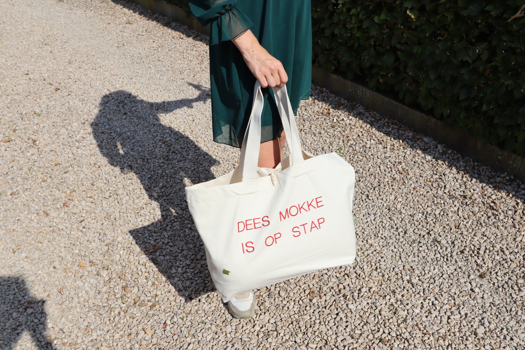 Beige shopper met de in het rood geborduurde tekst 'Dees mokke is op stap' – De Mokkes